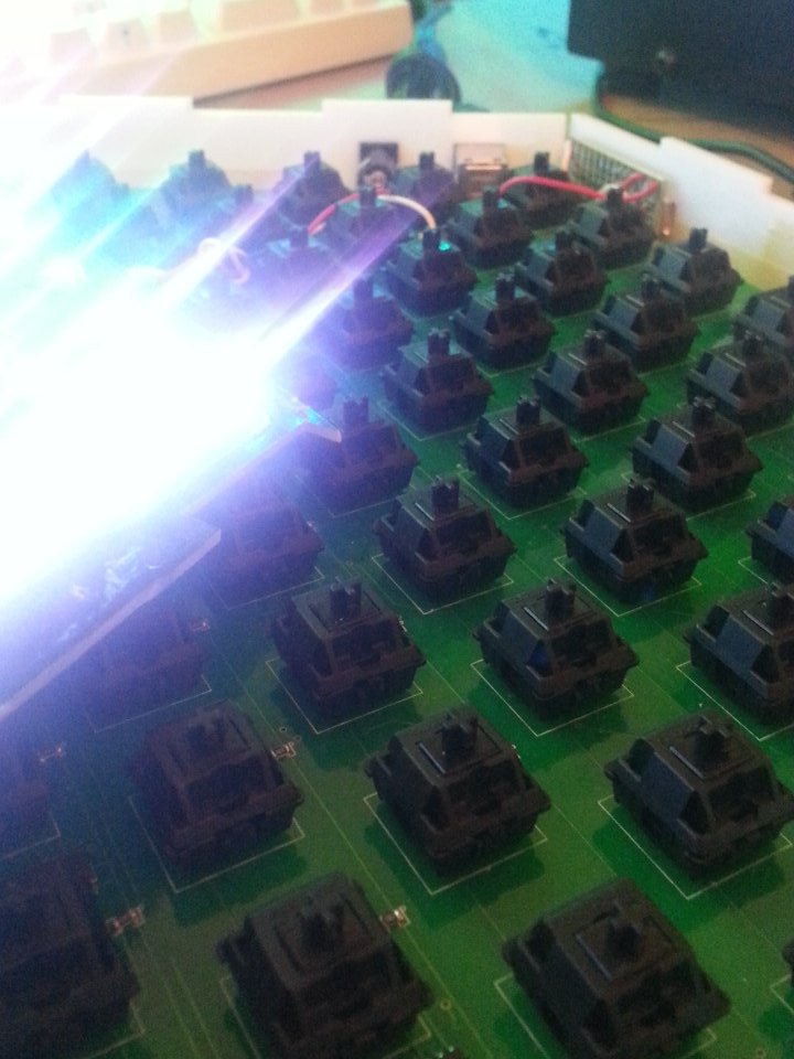 an extremely blurry and glare-ridden image of a PCB with
	hexagonally arranged Cherry MX Black keyswitches.
	There is a Teensy, a barrel jack, and a USB Type-B connector at the
	edge