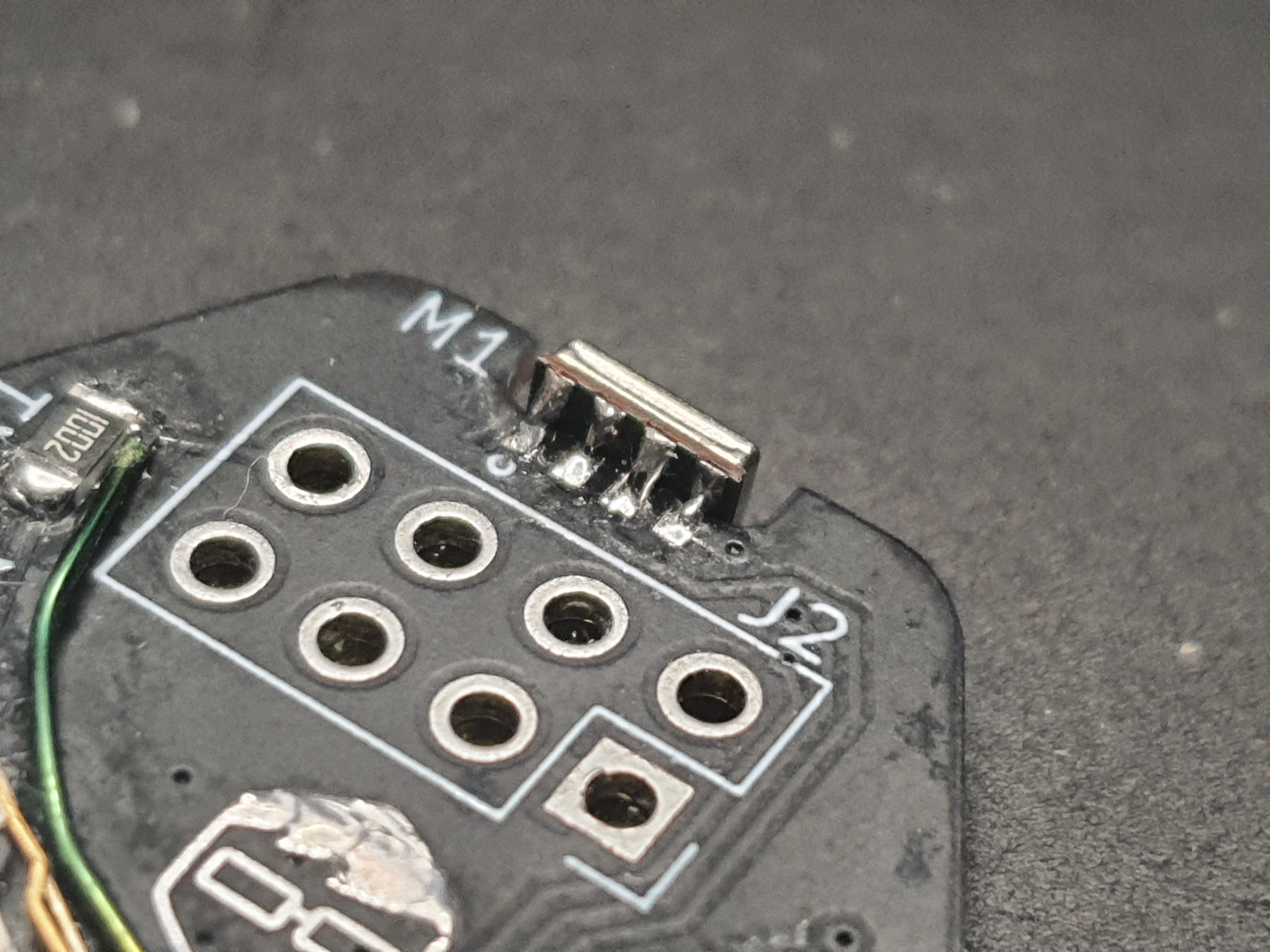 Close-up of a populated circuit board showing a MEMS microphone IC soldered perpendicular to the board on the edge